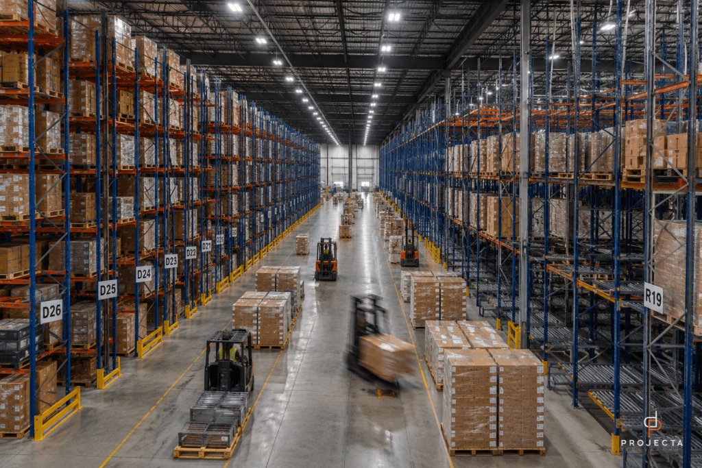 High-density pallet racking system inside a large Texas distribution warehouse with forklifts operating between storage aisles 